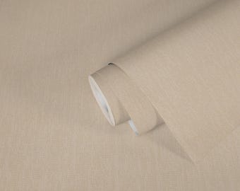 May include: A roll of beige wallpaper with a subtle textured pattern. The wallpaper is partially unrolled, revealing the white backing. The neutral color and simple design suggest a versatile home decor product.