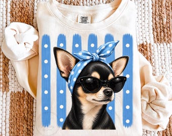 May include: A cream-colored crewneck sweatshirt featuring a graphic of a black and tan chihuahua wearing black sunglasses and a blue polka-dot headscarf. The background of the graphic consists of vertical blue stripes with white dots.