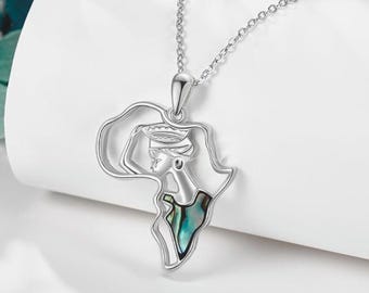 Op de afbeelding: Zilveren ketting met een hanger in de vorm van de omtrek van Afrika. De hanger toont het profiel van een vrouw met een hoofdtooi en een inleg van groene en blauwe abalone-parelmoer.