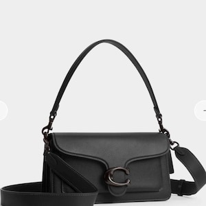 Puede incluir: Bolso de hombro de cuero negro con cierre de solapa y un gran logotipo "C" de metal oscuro. El bolso tiene una correa de hombro larga y ajustable y un asa más corta. Diseño minimalista y elegante.