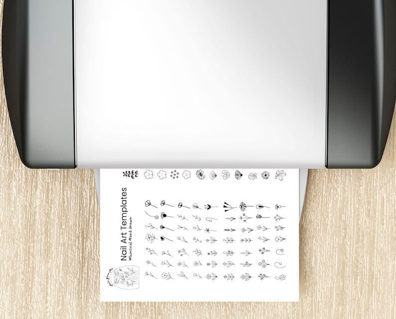A printable nail art template sheet coming out of a printer, showing rows of hand-drawn floral and botanical nail icons in black line art. The design sheet includes flowers, petals, leaves, branches, and tiny botanical shapes arranged neatly for easy tracing or stenciling. This image illustrates how customers can instantly download, print, and use the nail art templates to create DIY floral nail designs for gel nails or press-on nails.