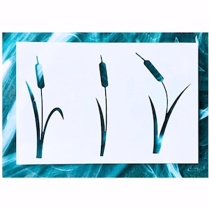 May include: A white rectangular stencil featuring three distinct dark teal cattail plant silhouettes. Each plant design displays a long slender stem, a single elongated seed head at the top, and two pointed leaves extending from the base of the stalk.