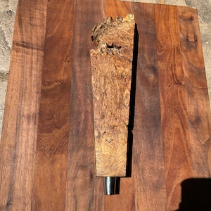 May include: A wooden beer tap handle with a natural wood finish and a metal tap.