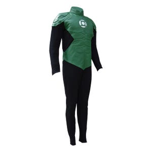 Puede incluir: Un disfraz de Green Lantern que consiste en un mono negro de manga larga con una pieza pectoral y hombreras verdes. La sección verde del pecho muestra un emblema circular blanco y detalles moldeados de músculos abdominales al frente.