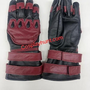 May include: Pair of black and burgundy gloves with a distinctive design. The gloves feature burgundy accents on the knuckles and wrist straps, with a black base. The text "Cosplayhunt.com" is visible on the gloves.
