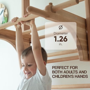 Op de afbeelding: Een kind hangt aan een houten speelstructuur met een stang van 3,2 cm diameter. De tekst "PERFECT VOOR ZOWEL VOLWASSENEN ALS KINDEREN" staat onder de stang.