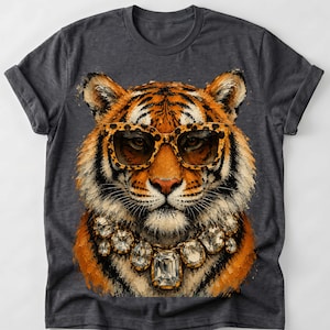 Könnte beinhalten: Ein anthrazitfarbenes Kurzarm-T-Shirt mit einem Grafikdruck eines Tigers, der eine Sonnenbrille mit Leopardenmuster und eine große, facettierte Kristallkette trägt. Der Tiger hat orangefarbenes, schwarzes und weißes Fell mit detaillierten Pinselstrichen.