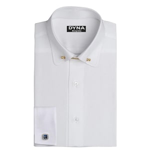 May include: A crisp white dress shirt with a classic collar and gold collar bar. The shirt features a button-down front and a cuff with a square, blue gemstone cufflink. The brand name "DYNA Bespoke" is printed on the collar.