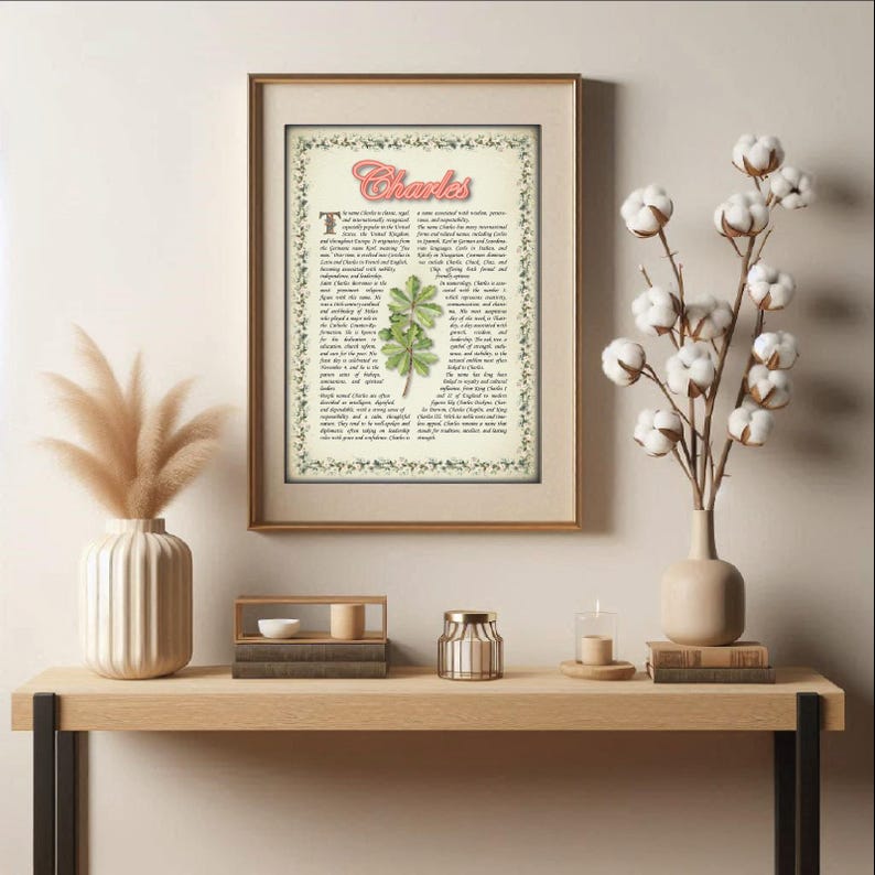 May include: A printable art print with a vintage aesthetic featuring the name "Charles" in a pink script font. The print includes a botanical illustration of a green leaf and a text block with a description of the name's meaning and origin.