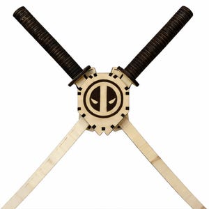 May include: Wooden Deadpool-themed crossed swords. The handles are wrapped in dark brown material, and the blades are light-colored wood. The center features a circular emblem with the Deadpool logo, a stylized eye design.
