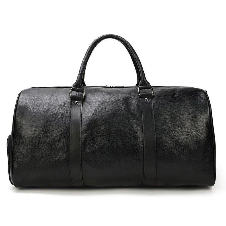 Pu&ograve; includere: Una borsa da viaggio in pelle nera con due manici superiori e una chiusura a zip.