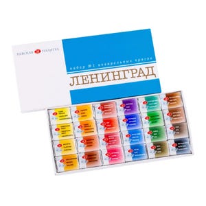 May include: A set of 24 watercolor paints in a white box with a blue lid. The lid has the text "набор №1 акварельных красок ЛЕНИНГРАД" in Russian. The paints are arranged in rows of four, with each paint having a small label with its name and color.