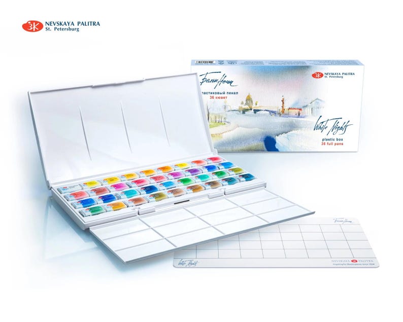 May include: A white plastic watercolor paint box with 36 full pans, open to reveal a rainbow of colors. The box is labeled "White Nights" and includes a separate mixing palette. The brand name "Nevskaya Palitra" is visible.