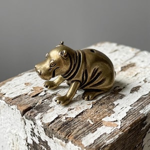 May include: A set of three ceramic mugs with a speckled, matte finish. The mugs are in shades of cream, light gray, and dark gray. Each mug has a simple, minimalist design and a rounded handle.