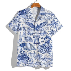 May include: White and blue button-down shirt with a patriotic design. The shirt features illustrations of the American flag, the Statue of Liberty, an eagle, and other patriotic symbols. The text "America 250" is also visible.