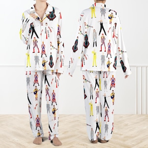 May include: White pajama set featuring a repeating pattern of colorful illustrations of a musician in various outfits. The long-sleeved top has a button-down front and the pants have a relaxed fit. The pajamas are made of a soft, lightweight fabric.