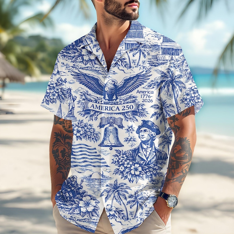 May include: White and blue button-down shirt with a patriotic design. The shirt features an eagle, the Liberty Bell, and a portrait of George Washington. Text includes "America 250" and "America 1776-2026". The shirt has short sleeves and a relaxed fit.