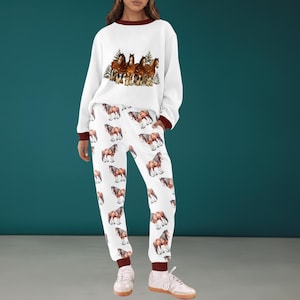 Peut inclure: Ensemble de surv&ecirc;tement blanc avec un motif de chevaux. Le sweat-shirt pr&eacute;sente un motif de chevaux marron et blanc et des bordures marron. Le pantalon de surv&ecirc;tement a un motif de chevaux r&eacute;p&eacute;t&eacute;. L'ensemble est en mati&egrave;re douce.