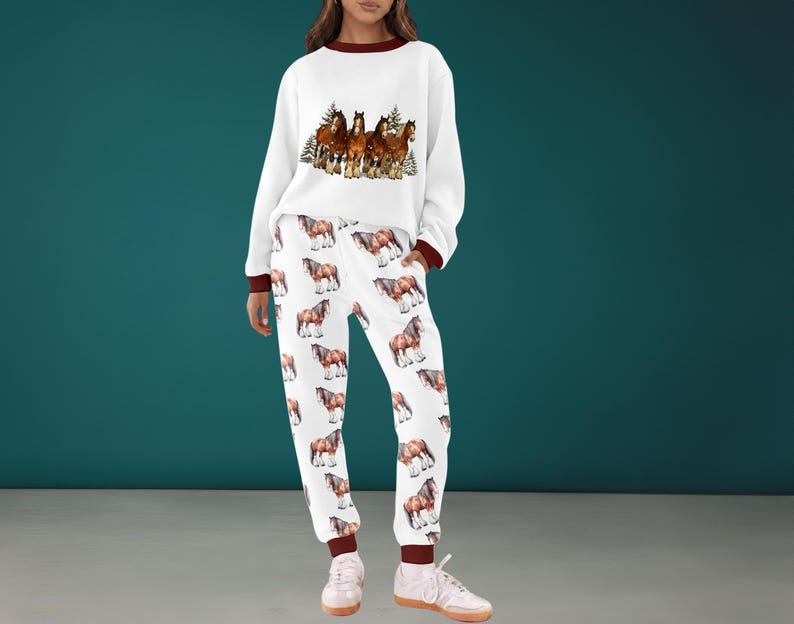 Peut inclure: Ensemble de surv&ecirc;tement blanc avec un motif de chevaux. Le sweat-shirt pr&eacute;sente un motif de chevaux marron et blanc et des bordures marron. Le pantalon de surv&ecirc;tement a un motif de chevaux r&eacute;p&eacute;t&eacute;. L'ensemble est en mati&egrave;re douce.