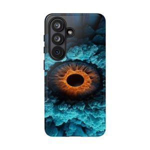Könnte beinhalten: Eine rechteckige Smartphone-Hülle mit einer hochauflösenden Grafik eines menschlichen Auges mit leuchtend orangefarbener Iris und dunkler Pupille. Das Auge ist von strukturierten, wolkenartigen Formationen in Blau- und Petroltönen umgeben.