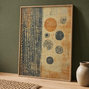 May include: A rectangular framed wall art piece featuring a split design. The left side displays vertical columns of dark blue and gold geometric patterns. The right side shows a textured tan background with various dark blue and orange circular motifs.