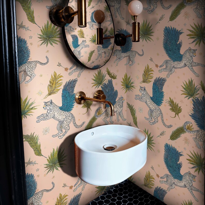 Powder room scene: Mystical Wallpaper with winged leopards, gothic blush-pink backdrop and tropical foliage; brass fixtures and round mirror echo Whimsical Wallpaper charm in a canvas peel-and-stick removable mural.