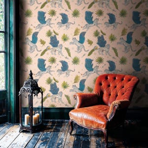 Vintage reading nook with caramel leather wingback chair and Moroccan lantern, walls dressed in Whimsical Winged Wildcat Wall Mural; Secret Garden Mural vibes from enchanted mythical leopard wallpaper on blush-pink ground.