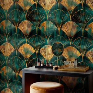 Pode incluir: Um conjunto de toucador com um fundo de papel de parede com padrão de leque Art Déco dourado e verde-azulado. O toucador tem uma mesa preta, um banco dourado, um espelho e uma bandeja com maquilhagem e frascos de perfume.