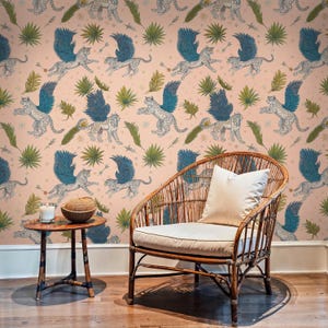 Boho sitting corner with rattan lounge chair and coconut candle framed by Tropical Wallpaper of winged wildcats and leafy botanicals; Boho Wallpaper peel-and-stick mural brings whimsical jungle energy to a cosy space.