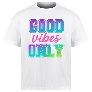 Peut inclure: T-shirt blanc avec l'inscription "GOOD vibes ONLY" dans un dégradé de violet, bleu, rose et vert. Le texte est souligné d'une couleur contrastante. Le t-shirt a un col rond et des manches courtes.