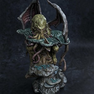 May include: A detailed sculpture of a creature with a green, textured head, tentacles, and large, dark wings. The sculpture is set on a rocky base with aquatic elements. The text "FULL SIZE TURNTABLE" is displayed at the bottom.