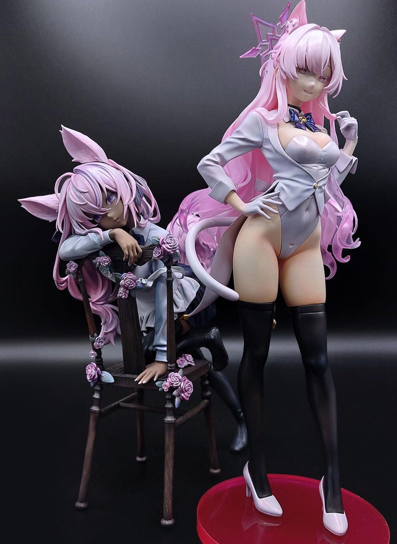 May include: Two anime figurines of a female character with pink hair and bunny ears. The figurine on the left is sitting on a wooden chair with pink roses. The figurine on the right is standing with a white dress and black stockings.