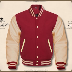 May include: Maroon wool body jacket with cream leather sleeves. It has a button-up front, cream sleeves, and striped cuffs and waistband. The jacket is a classic varsity style.