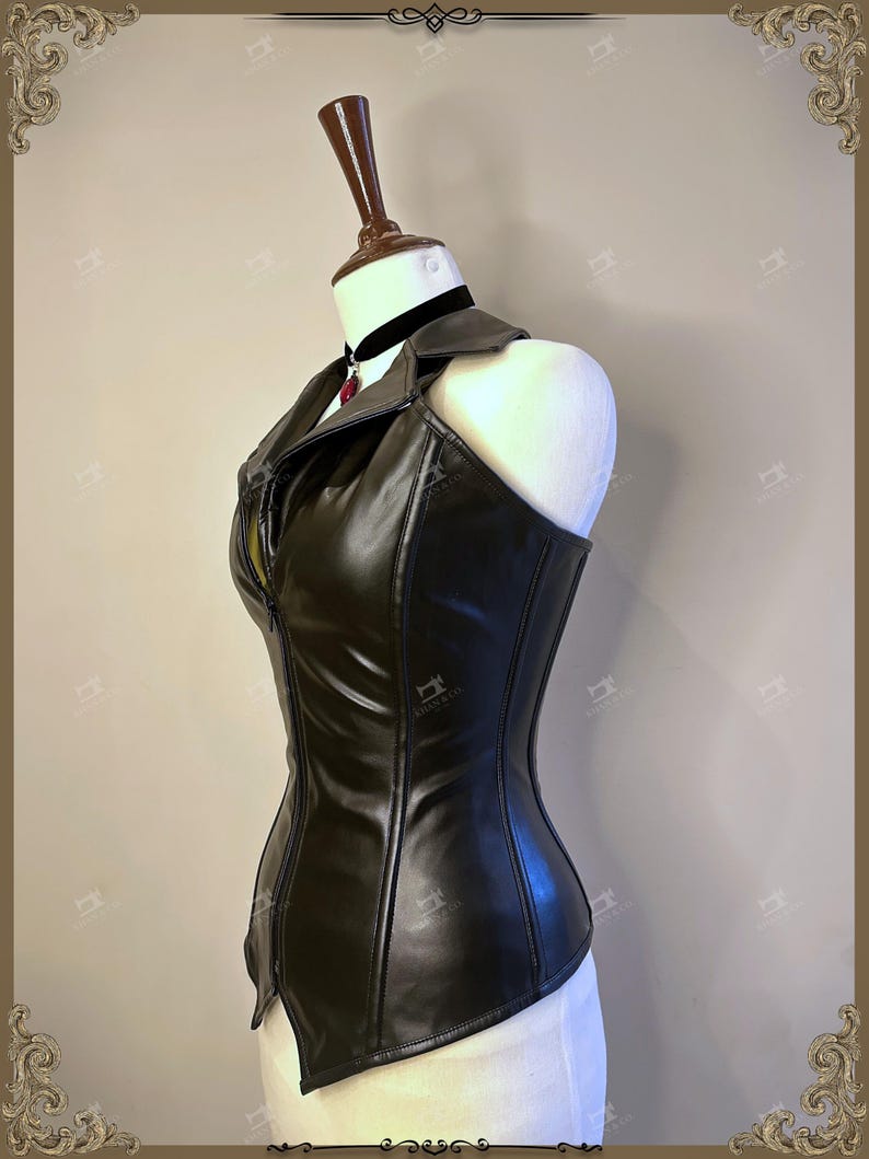 May include: A black faux leather corset with a zipper closure and a collar. The corset is displayed on a mannequin and features a fitted silhouette. A black choker with a red pendant is visible.