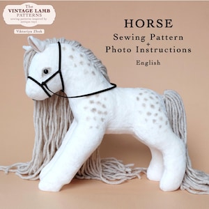 Könnte beinhalten: Ein weißes Plüschpferd mit braunen Flecken und einer langen, fließenden Mähne und Schweif. Das Pferd hat ein schwarzes Halfter und ist ein Schnittmuster mit Fotoanleitungen. Der Text auf dem Bild lautet "HORSE Sewing Pattern + Photo Instructions English."