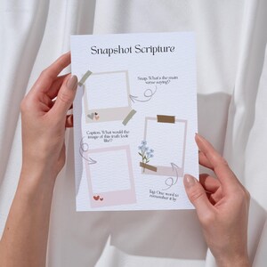 K&ouml;nnte beinhalten: Ein druckbares Arbeitsblatt mit einem rosa und braunen Rahmen-Design. Das Arbeitsblatt tr&auml;gt den Titel "Snapshot Scripture" und enth&auml;lt Anleitungen f&uuml;r eine Bibellesestunde. Die Anleitungen beinhalten "Snap: Was sagt der Hauptvers?", "Bildunterschrift: Wie w&uuml;rde das Bild dieser Wahrheit aussehen?" und "Markiere ein Wort, um es sich zu merken."