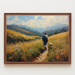 Op de afbeelding: Olieverfschilderij van een figuur in witte en blauwe gewaden die met een lam over een pad door een veld met wilde bloemen loopt. Bergen en een blauwe lucht zijn op de achtergrond. Het kunstwerk is ingelijst in een bruine houten lijst.