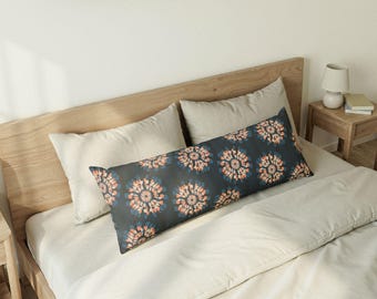 Almohada corporal estilo boho con estampado tie-dye azul y naranja.