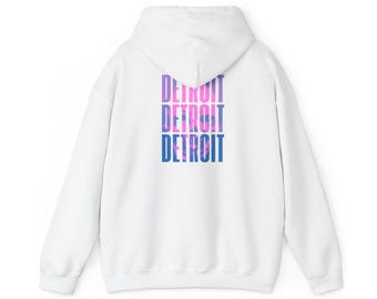 Peut inclure: Sweat à capuche blanc avec le mot "DETROIT" imprimé trois fois dans un dégradé de violet, rose et bleu. Le sweat à capuche a une capuche et des manches longues. Le design est centré au dos.