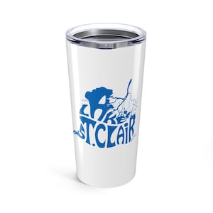 May include: White travel mug featuring a blue graphic of a tree and the words "ST. CLAIR". The mug has a silver lid and is designed for hot or cold drinks. A travel mug for everyday use.