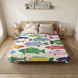 May include: A cream-colored bedspread featuring a repeating pattern of stylized fish in various colors including green, blue, yellow, pink, and red. The fish are depicted with simple shapes and dotted or striped textures across the fabric surface.