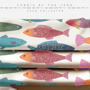 May include: Spun polyester fabric by the yard featuring a repeating pattern of fish in shades of orange, pink, blue, and green on a cream background. The text FABRIC BY THE YARD and SPUN POLYESTER is printed at the top of the image.