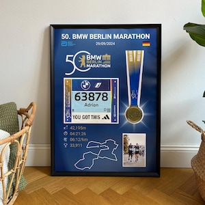 Könnte beinhalten: Gerahmter Gedenkdruck für den 50. BMW Berlin Marathon. Der Druck enthält eine Startnummer mit der Nummer 63878, eine Medaille und Renndetails. Der Text "YOU GOT THIS" ist ebenfalls sichtbar.