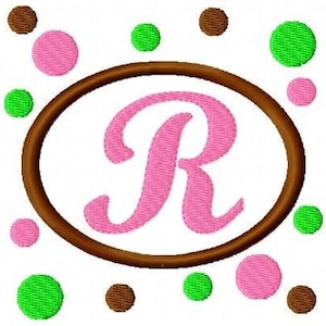 May include: A brown oval frame with a pink letter R inside. The frame is surrounded by pink, green, and brown polka dots.