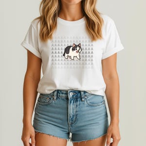 May include: White t-shirt with a black and white cartoon cat with the text "AAAAAAA" repeated on the shirt.