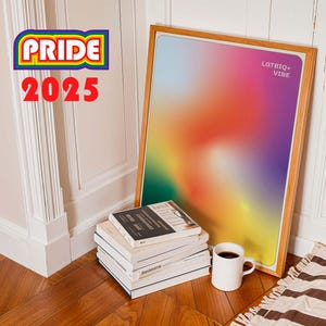 May include: A framed art print with a vibrant, colorful gradient, with the text "LGTBIQ+ VIBE". The print is leaning against a wall next to a stack of books and a white mug. The words "PRIDE 2025" are in the upper left corner.