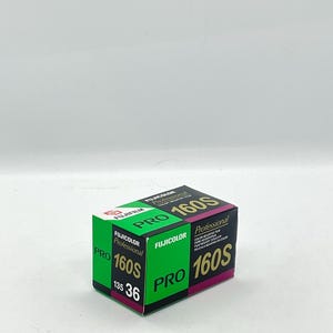 Puede incluir: Una caja de película negativa en color Fujifilm Fujicolor Pro 160S. La caja es verde, negra y magenta, con el texto "FUJIFILM" y "Professional" en un lugar destacado. La película es de formato 135 con 36 exposiciones.