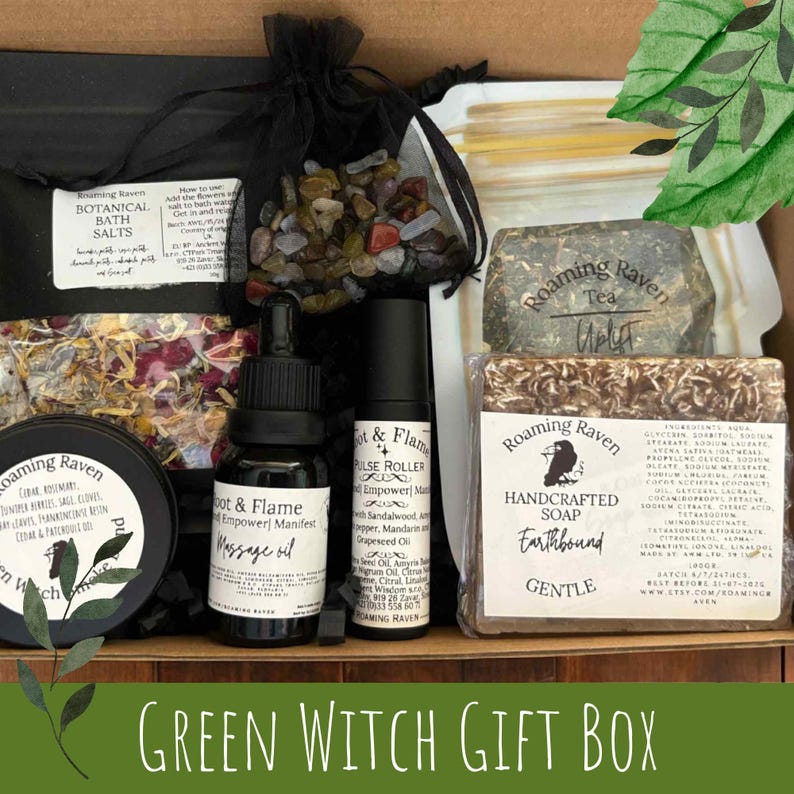 May include: A Green Witch Gift Box filled with botanical bath salts, massage oil, pulse roller, handcrafted soap, and a bag of crystals. The box includes products from Roaming Raven, with text labels and a green theme.
