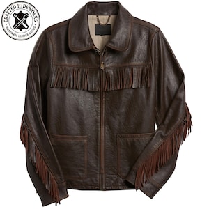 May include: A brown leather jacket with fringe detailing across the chest and sleeves. The jacket has a zip-up front, two front pockets, and a collar. The image includes a circular logo that reads "Crafted Hideworks Handmade Leather Goods."