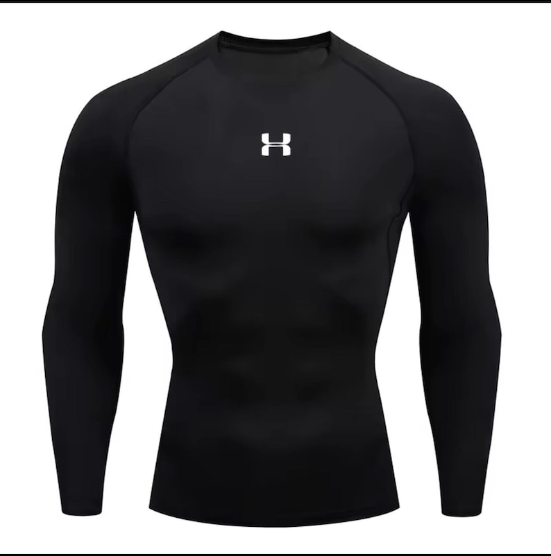 May include: Black compression shirt with long sleeves. The shirt has a crew neck and a white logo on the chest. The fabric appears to be form-fitting and designed for athletic activities.